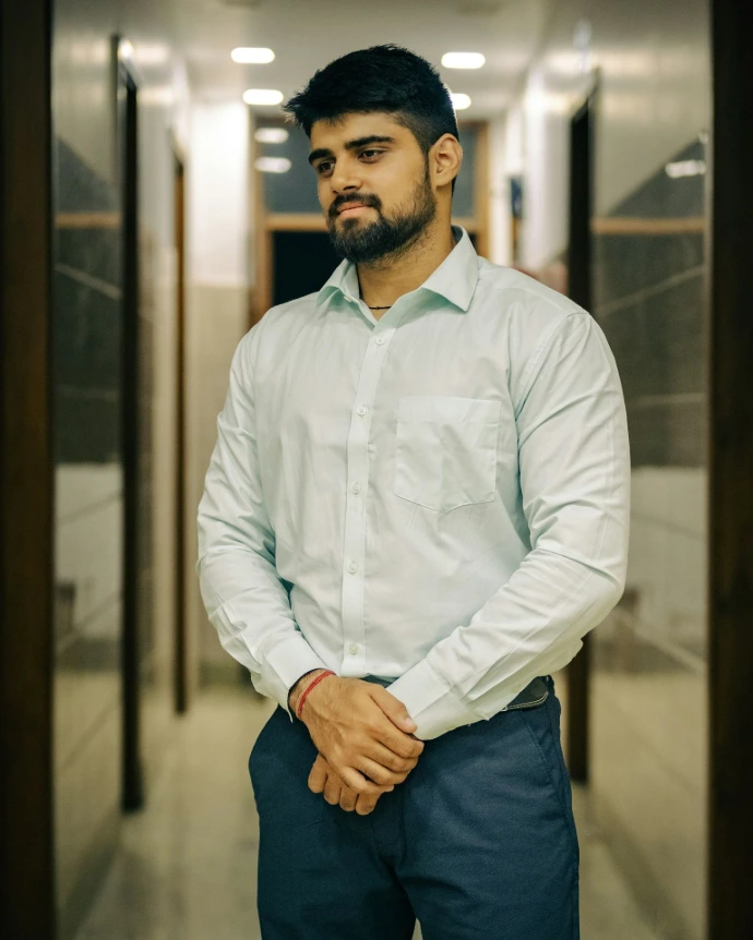 A man standing in a hallway with his hands in his pockets